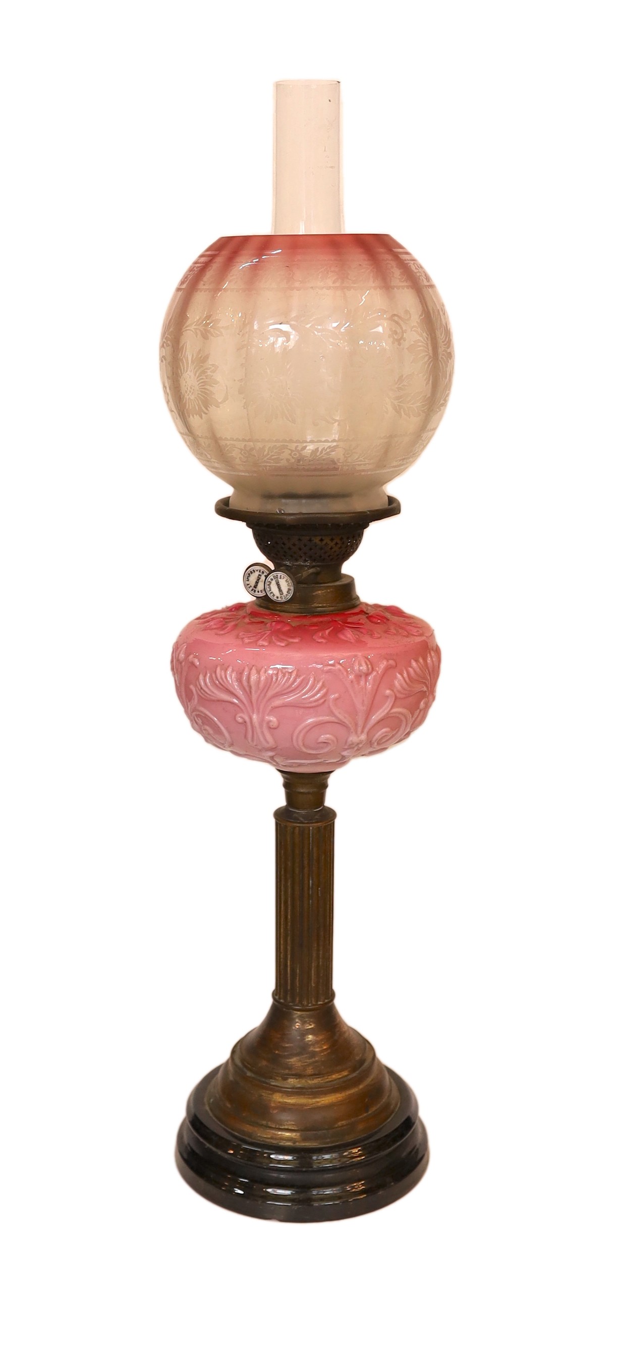 A late Victorian brass and opaque pink glass oil lamp, with Burnes duplex mechanism, pink tinted etched glass globe and flue, height overall 71cm